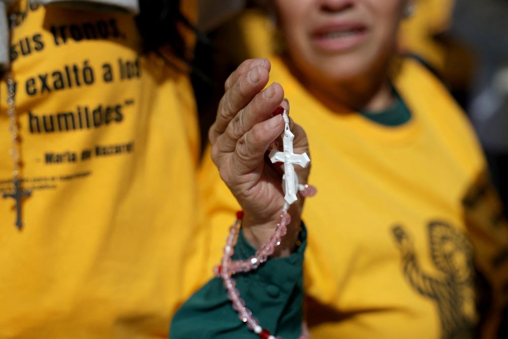 A woman holds a rosary as members of a Catholic group take part in a Eucharistic procession near the U.S. Immigration and Customs Enforcement Broadview facility in Chicago Oct. 11. The group had hoped to share Communion with detainees at the facility. (OSV News/Jeenah Moon, Reuters)