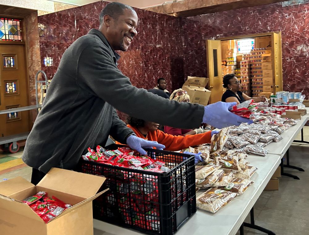 Anthony, a volunteer at the St. Benedict Church food pantry in Philadelphia, hands out dried fruit to a client during an Oct. 31 distribution that took place hours ahead of the scheduled Nov. 1 lapse in funding for SNAP, the Supplemental Nutrition Assistance Program, amid the federal government shutdown. (OSV News/Gina Christian)