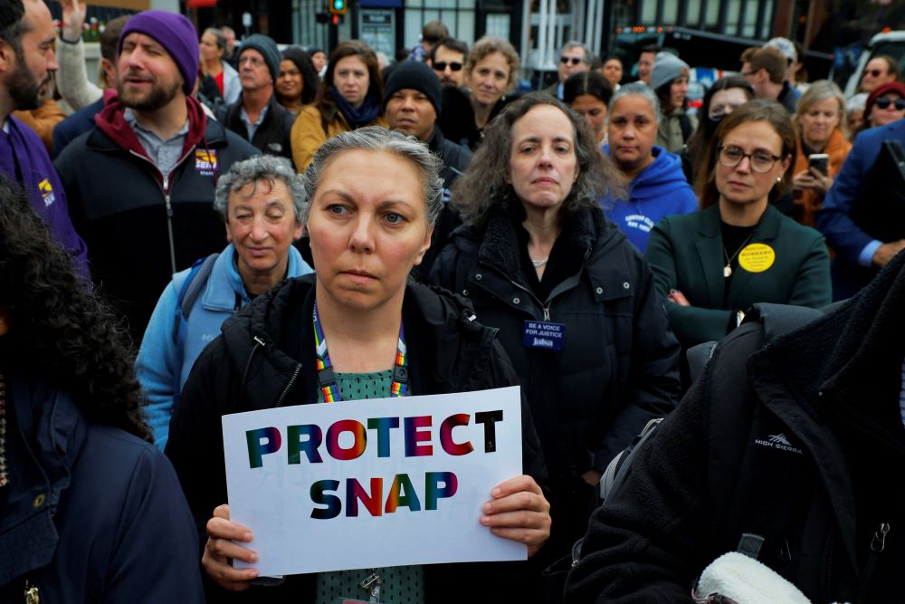 A woman holds a sign during "A Rally for SNAP" on the steps of the Massachusetts Statehouse in Boston Oct. 28 ahead of the anticipated suspension of food aid benefits Nov. 1 amid the ongoing U.S. government shutdown. (OSV News/Brian Snyder, Reuters)