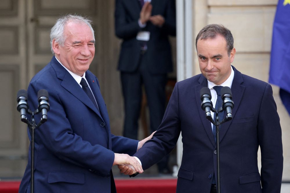 Newly appointed French Prime Minister Sébastien Lecornu, right, shakes hands with outgoing Prime Minister Francois Bayrou Sept. 10. 