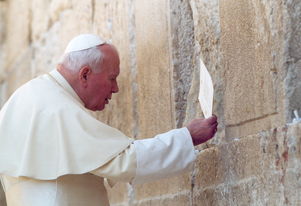 Pope John Paul II places a prayer in a crevice of the Western Wall, Judaism's holiest site, March 26, 2000. Speaking to ecumenical leaders on the historic trip that included visits to Jordan, Israel and the Palestinian territories, the pontiff prayed that the Holy Land would be a homeland to all faiths and peoples. (CNS file photo/Arturo Mari)