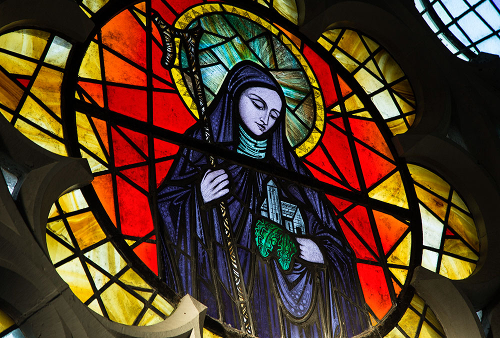 St. Brigid of Kildare is pictured in a stained-glass window in St. Brigid's Church in Crosshaven, a village in County Cork, Ireland. (CNS/Cillian Kelly)
