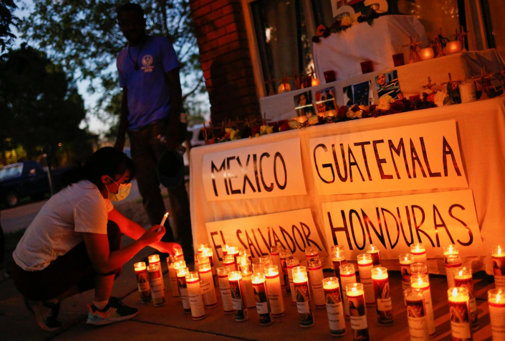 A woman in El Paso, Texas, lights candles during a vigil July 5, 2022, to honor the 53 migrants who died in a cargo truck in San Antonio June 27. (CNS/Reuters/Jose Luis Gonzalez)