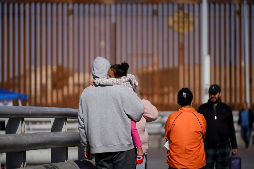Cuban migrant Marielis Arosh and her family walk with other migrants after their CBP One app asylum appointment was cancelled on the day of U.S. President Donald Trump's inauguration, near the border fence in Mexicali, Mexico, Jan. 20, 2025. (OSV News/Reuters/Victor Medina)