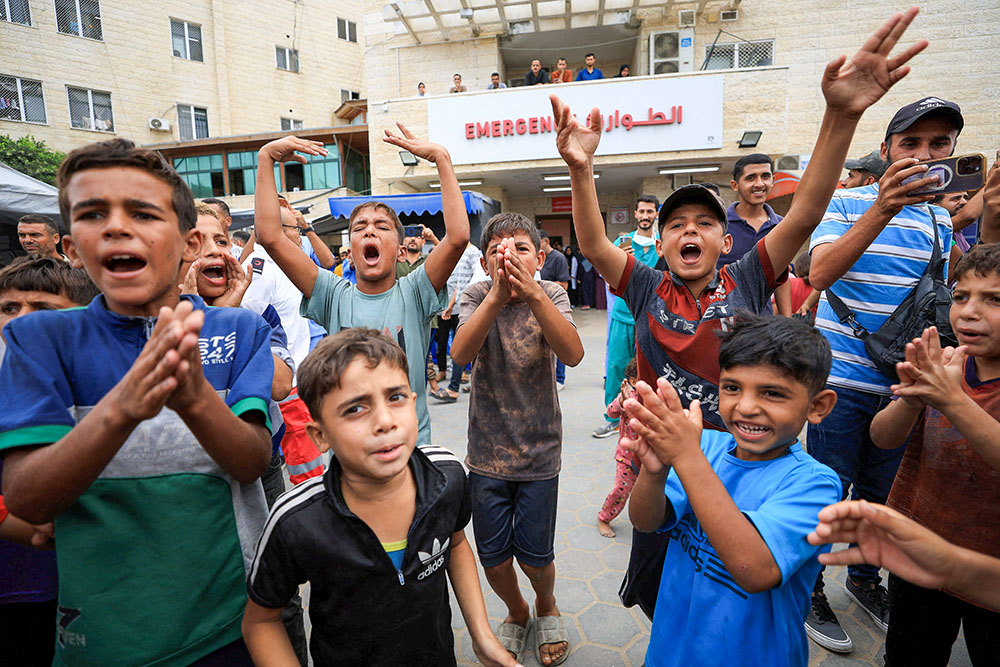 Palestinian children celebrate in Khan Younis in the southern Gaza Strip after U.S. President Donald Trump announced that Israel and Hamas agreed on the first phase of a Gaza ceasefire Oct. 9, 2025. (OSV News/Reuters/Dawoud Abu Alkas)