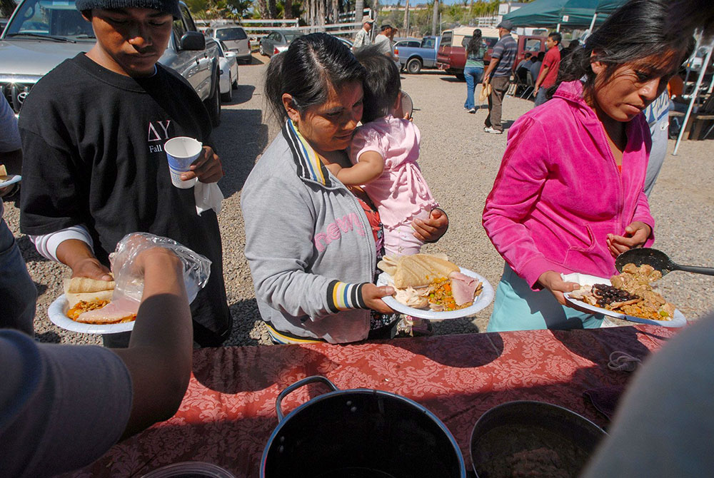 A file photo shows migrant workers receiving lunch in San Diego, helped by parishioners from a local Catholic church that assists laborers in the area. (OSV News/David Maung)