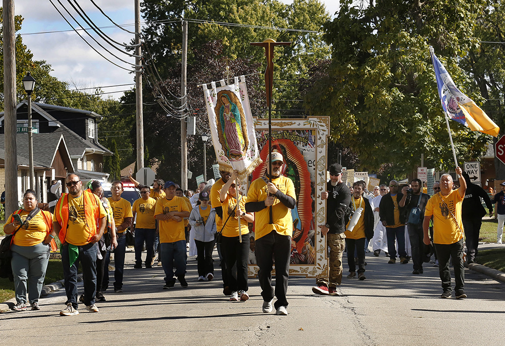 Immigrant activists make their way down Lexington St. on the way to the U.S. Immigration and Customs Enforcement facility in Broadview, Oct. 11 in Chicago. Hundreds followed the Eucharist from St. Eulalia Parish in Maywood to the Broadview facility operated by the Department of Homeland Security. The group hoped to give Communion to detainees at the center but were denied access. (Chicago Catholic/Karen Callaway)