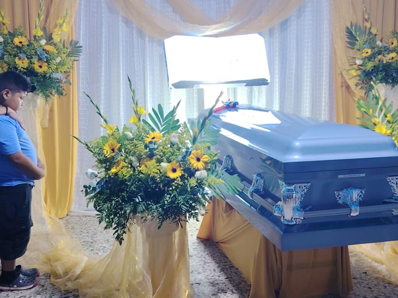 Roberto Carlos Montoya Valdez's grandson looks at his grandfather's casket, with the Superman doll that he had given him resting on top. Montoya Valdez's funeral took place Sept. 7 in his hometown of Jutiapa, Guatemala. (Courtesy of the Montoya family)
