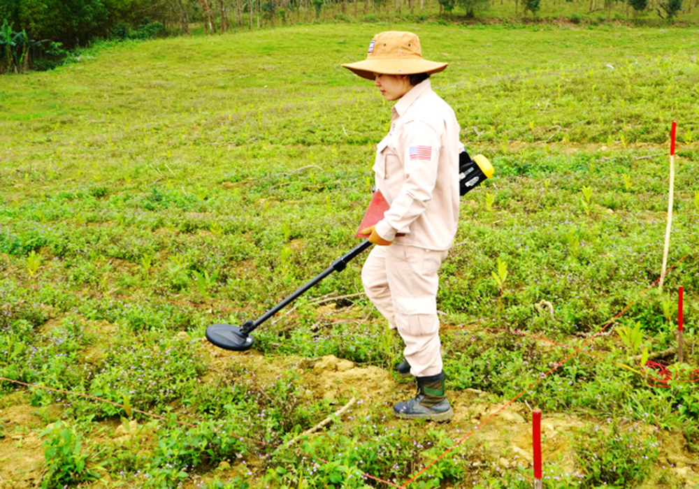 A female deminer carries out a search for unexploded ordnance in an abandoned garden in Cam Lo, Quang Tri province, Vietnam, on Aug. 28. (NCR photo) 