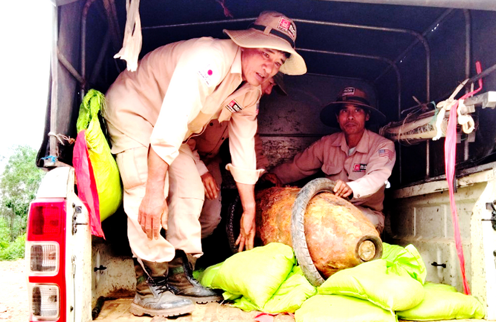 Deminers load a bomb onto a truck for transport to a designated disposal site on Aug. 28. (NCR photo)