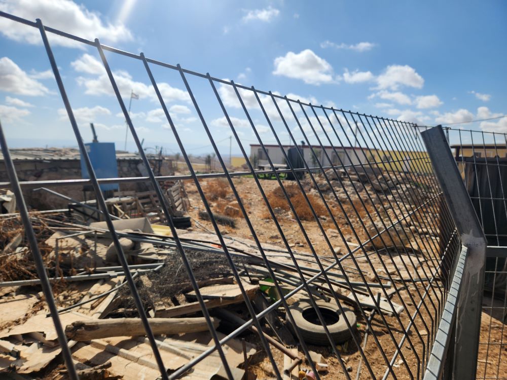 A chain-link fence stands between Israeli settler property and the property of the Bedouin village of Umm al-Khair in the Israeli-occupied West Bank. 