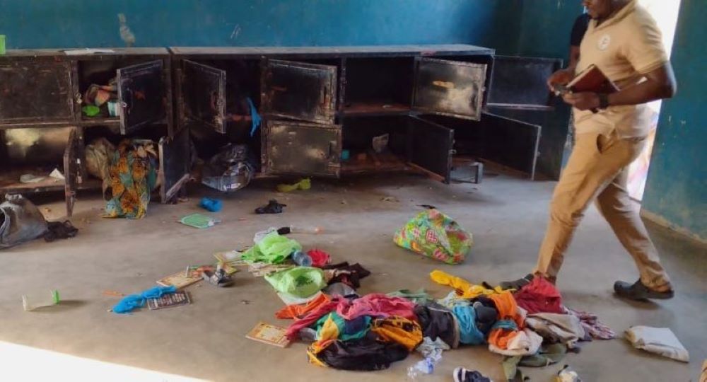 A man walks past belongings at the St. Mary's Catholic Primary and Secondary School after gunmen abducted children and staff in Papiri community, Nigeria.