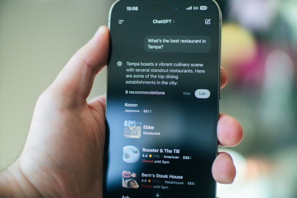 Hand holds cellphone that shows ChatGPT search.