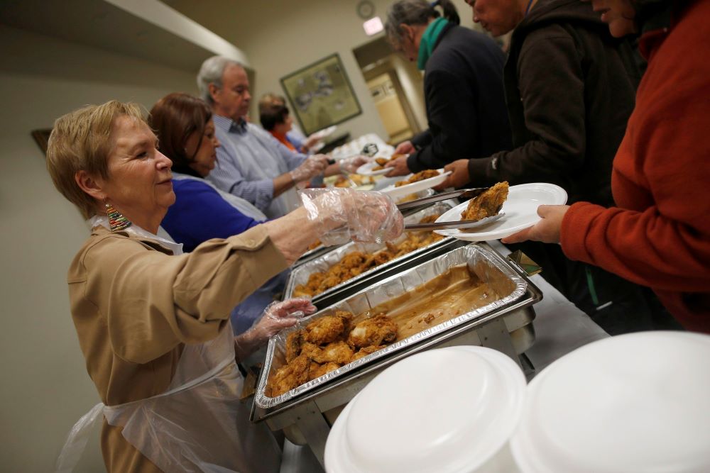 Volunteers are pictured in a file photo serving people in need during a free dinner provided by the Emergency Assistance Department of Chicago Catholic Charities. (OSV News/Jim Young, Reuters)
