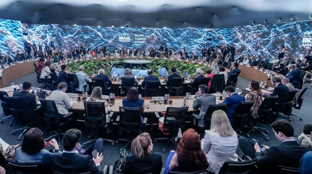 Group of people sit at tables that create a circle.