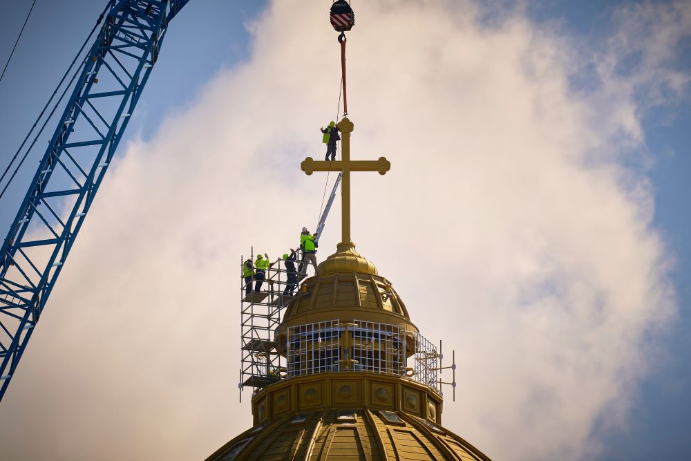 Construction workers install the main cross of the People's Salvation Cathedral in Bucharest, Romania. 