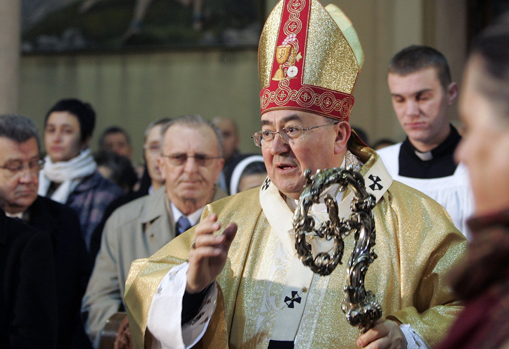 Cardinal Vinko Puljić of Sarajevo, Bosnia-Herzegovina, blesses the congregation as he enters the central Sarajevo cathedral to celebrate Christmas morning prayers Dec. 25, 2008. (CNS/Reuters/Danilo Krstanovic)
