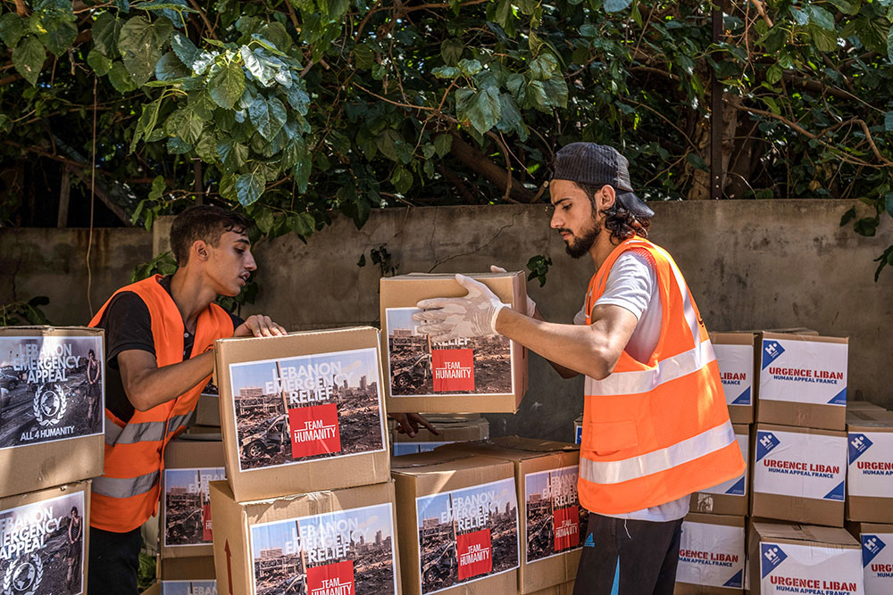 Workers with Caritas Lebanon, in partnership with Catholic Relief Services, are pictured in an undated photo distributing food and hygiene kits to people who were affected by an Aug. 4, 2020, blast in Beirut's port area. (OSV News/Stefanie Glinski for Catholic Relief Services)