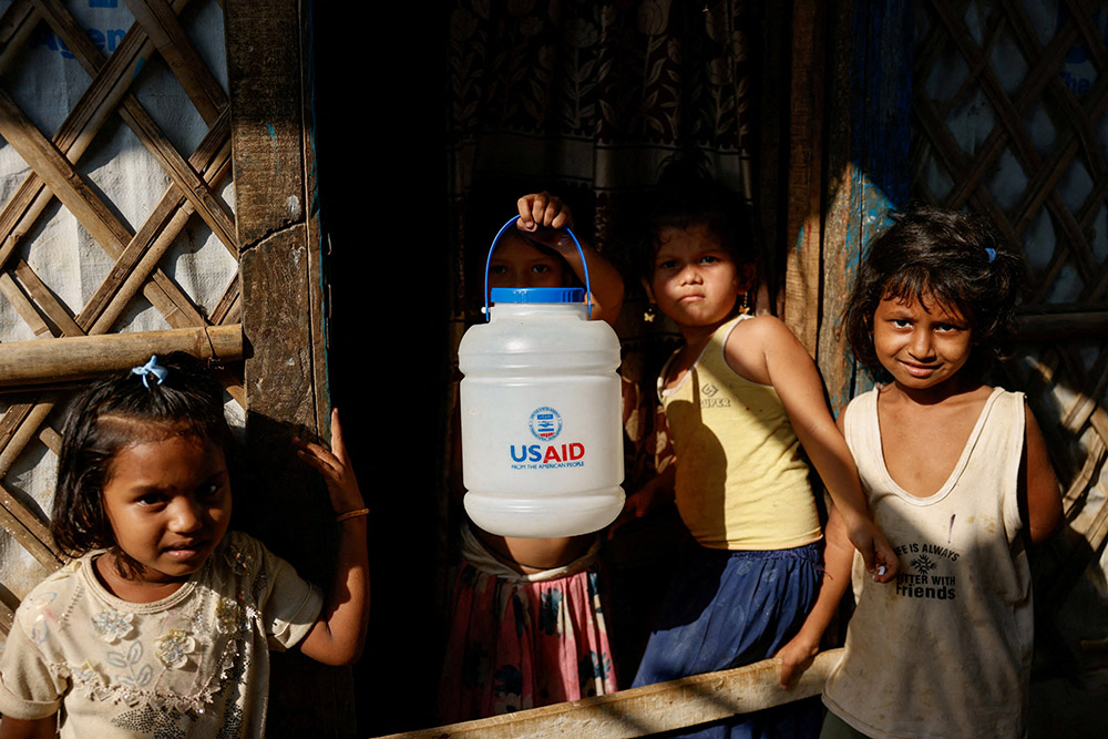 A Rohingya refugee girl holds a jar with U.S. Agency for International Development logo imprinted, at the refugee camp in Cox's Bazar, Bangladesh, March 16, 2025. The Trump administration moved March 28 to formally close USAID and fold remaining functions into the State Department. (OSV News/Reuters/Mohammad Ponir Hossain)
