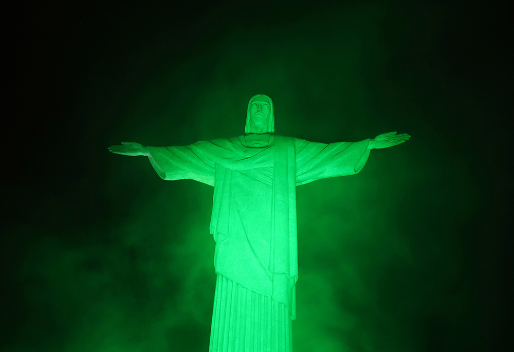 The statue of Christ the Redeemer is lit up in green on World Environment Day in Rio de Janeiro, June 5, 2025. Brazil is playing host to the COP30 United Nations climate change conference Nov. 10-21 in Belém. (OSV News/Reuters/Pilar Olivares)