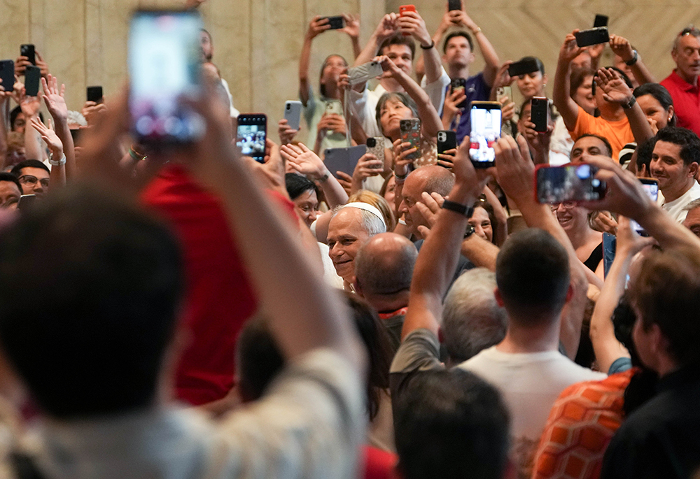 In this file photo from June 14, 2025, Pope Leo XIV greets people as they hold up cellphones to take photos and videos as he enters St. Peter’s Basilica for an audience with pilgrims in Rome for the Holy Year 2025. (CNS/Lola Gomez)