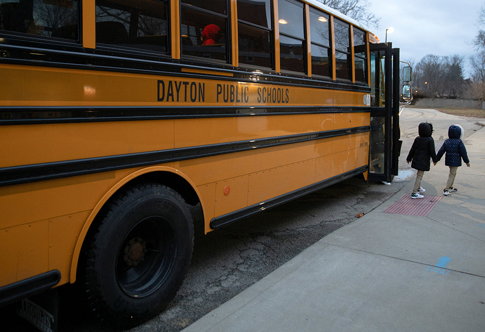 A file photo shows a public school bus dropping students off at an elementary school in Dayton, Ohio. (OSV News/Reuters/Megan Jelinger)