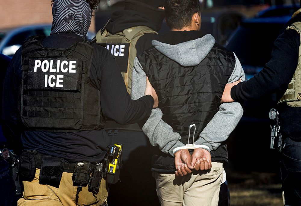 Agents with the Immigration and Customs Enforcement detain a man after conducting a raid at the Cedar Run apartment complex in Denver Feb. 5, 2025. (OSV News photo/Reuters/Kevin Mohatt)