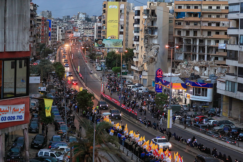 The convoy escorting Pope Leo XIV drives past war-damaged buildings in Beirut, Lebanon on Nov. 30, 2025, following his arrival. (AP Photo/Mohammed Zaatari)