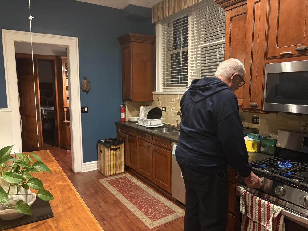 Fr. Dennis Berry turns on the stove in the kitchen of St. James Parish’s rectory in the South Side neighborhood of Chicago, Oct. 26, 2025. (NCR photo/Camillo Barone)