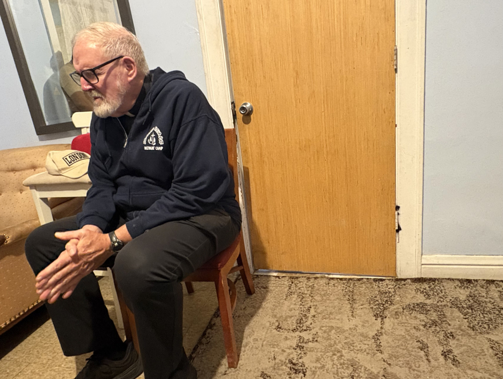 Fr. Dennis Berry prays with Venezuelan immigrants at their home in South Side Chicago, Oct. 26, 2025, after bringing them back home from his parish's rectory, where they did their laundry safely. (NCR photo/Camillo Barone)