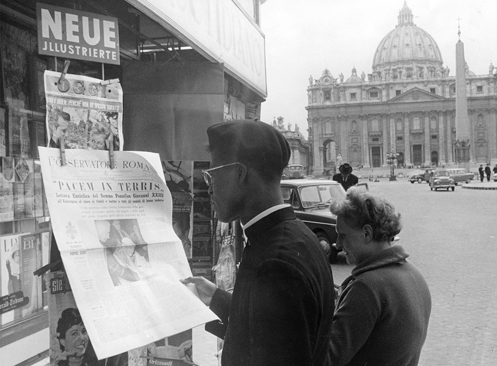 A priest and a woman stop at a news stand at St. Peter's Square, April 10, 1963, to look at the Vatican newspaper L'Osservatore Romano, with the Latin text of Pope John XXIII's encyclical Pacem in Terris. (AP/Girolamo Di Majo)