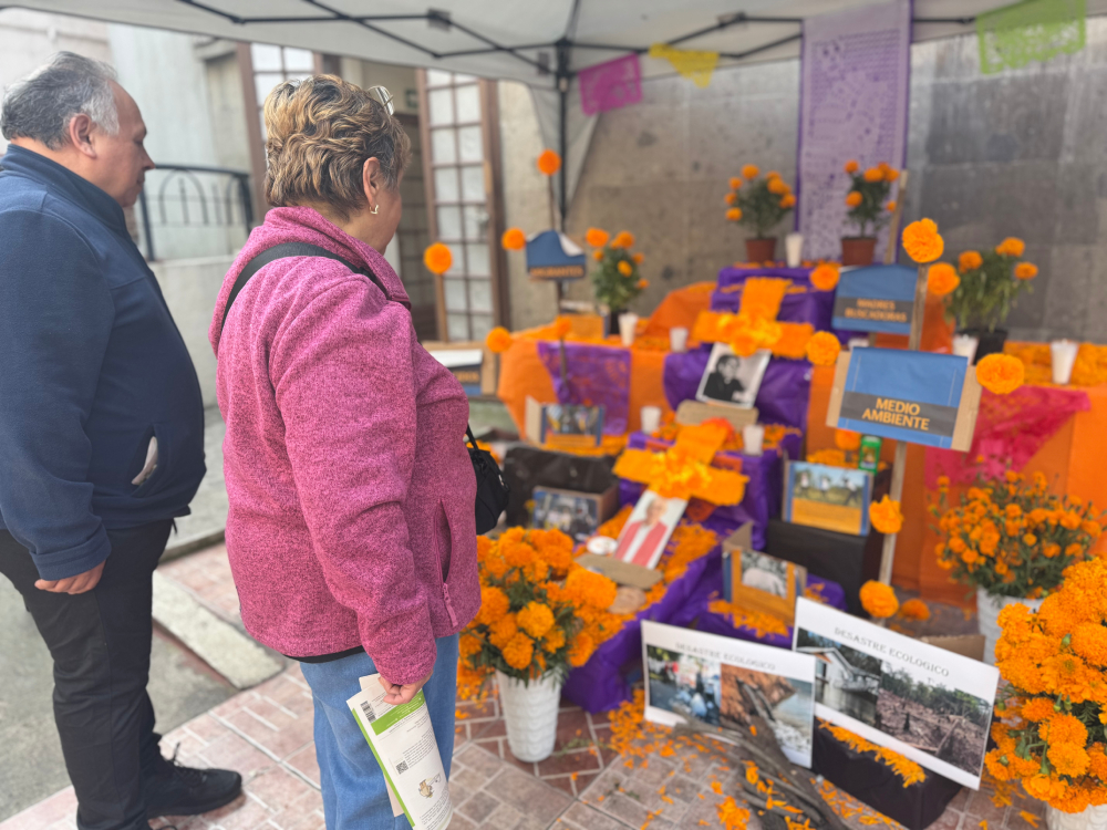 Two people stand and observe a Day of the Dead display which highlights environmental destruction and some of Mexico's missing people, among other things. (GSR photo/Rhina Guidos)