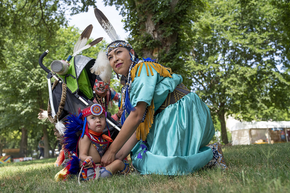 T'ata Begay, of the Choctaw/Taos Pueblo Nations in Oklahoma, gets her son, Okhish Homma Begay, 2, who is of the Navajo and Chocktaw/Taos Pueblo Nations, ready for a performance on the National Mall in Washington, D.C., on June 26, 2024. (AP/Jacquelyn Martin)