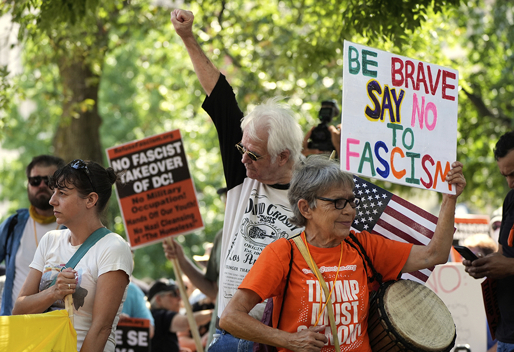 Activists carry signs during a protest against President Donald Trump's federal takeover of policing of the District of Columbia, Saturday, Aug. 16, 2025, in Washington. (AP photo/Alex Brandon)