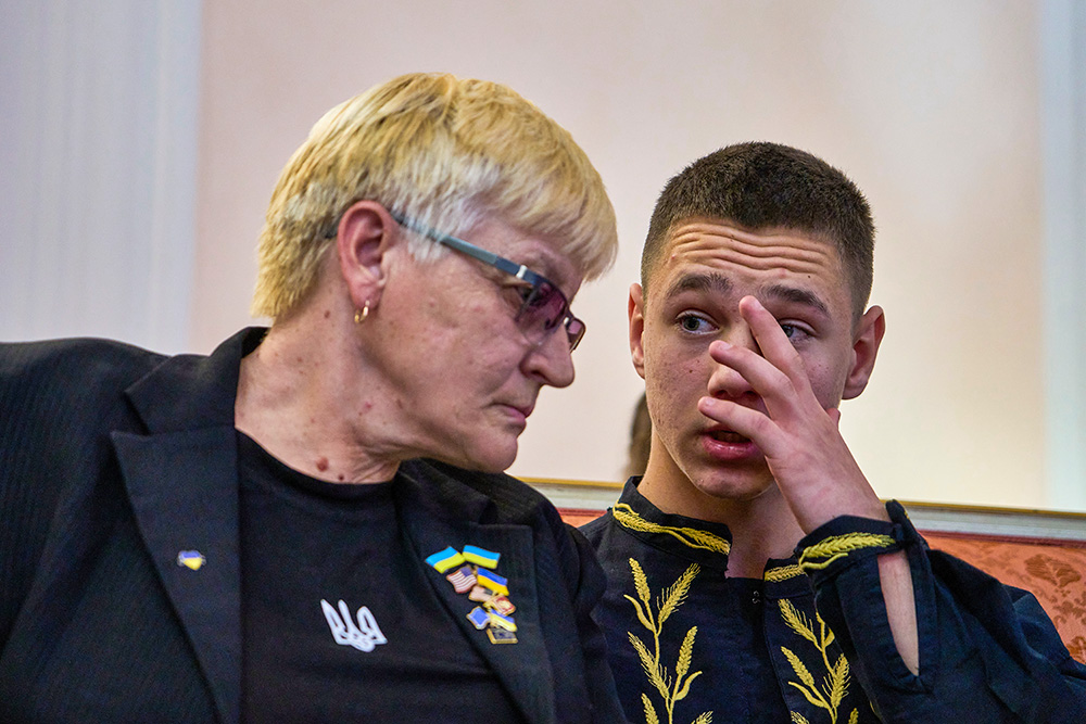 Liudmyla Siryk, left, listens to her grandson, Oleksandr Radchuk, during a press conference on the return of Ukrainian children and civilians taken by Russia during the three-and-a-half-year war, at the Embassy of Ukraine in Italy, in Rome Nov. 19, 2025. (AP/Domenico Stinellis)