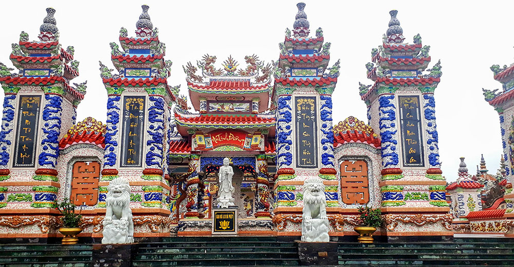 The temple-like tomb of 88-year-old Ho Thiet's family stands as a striking landmark in the cemetery. At its entrance is a stone Buddha, two carved lions and ornate pillars decorated with Buddhist symbols, dragons and poetic couplets. (Joachim Pham)