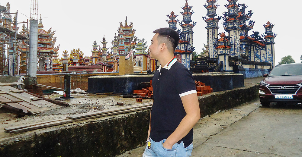 Luke Pham Van Quoc visits his grandfather's grave at the cemetery on Oct. 25, 2025, pausing amid the rows of elaborate tombs that stretch toward the sea. (Joachim Pham)