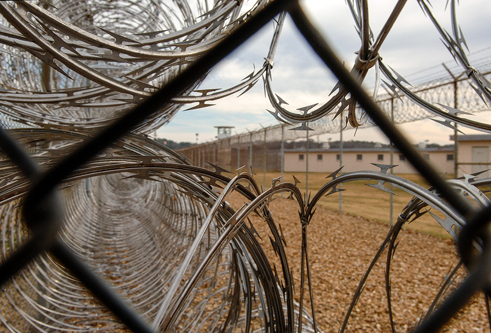 Razor wire and a watchtower are seen at Louisiana State Penitentiary at Angola in 2007. Two inmates there, half-brothers Bernard Joseph and Marcus Hamilton, are serving life terms for murdering Josephite Fr. Patrick McCarthy in 1988. They accuse McCarthy and another Josephite priest of sexual abuse. (Newscom/ZUMA Press/Robin Nelson)
