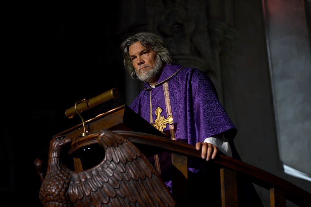 Josh Brolin plays Msgr. Jefferson Wicks, seen in pulpit.