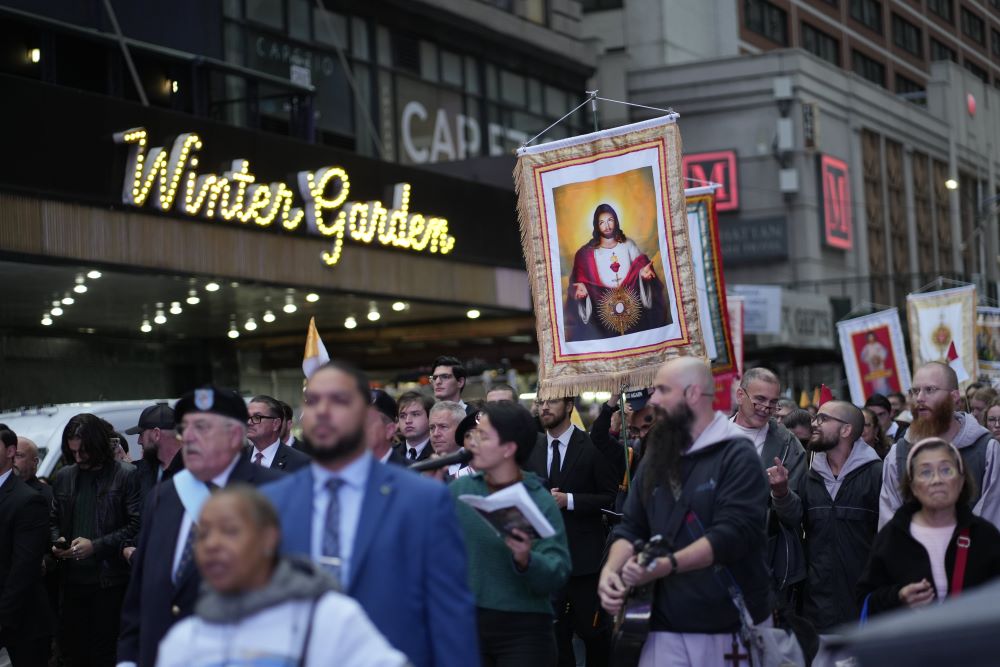 A participant carries a banner featuring an image of the Sacred Heart of Jesus during the fifth annual Napa Institute-sponsored eucharistic procession through Midtown Manhattan in New York City Oct. 14. 