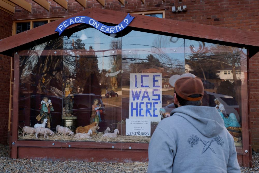 A sign reading "ICE Was Here" stands in the outdoor Nativity at St. Susanna Catholic Church in Dedham, Mass.