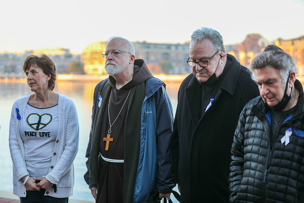 Jesuit Fr. Gerard McGlone, second from right, is seen with Jennifer Wortham, far left, and Boston Cardinal Sean O'Malley, president of the Pontifical Commission for the Protection of Minors, in prayer during a sunrise walk to end abuse Nov. 18, 2021, outside the hotel in Baltimore where the U.S. Conference of Catholic Bishops was holding its fall general assembly. (CNS photo/Bob Roller)