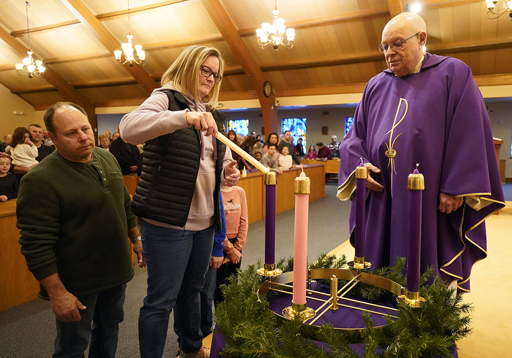 Laura Klein lights a candle on the Advent wreath as her husband, Bob Klein, and Msgr. Daniel Picciano look on during Mass on the first Sunday of Advent at St. Sylvester Church in Medford, New York, Nov. 27, 2022. (CNS/Gregory A. Shemitz)