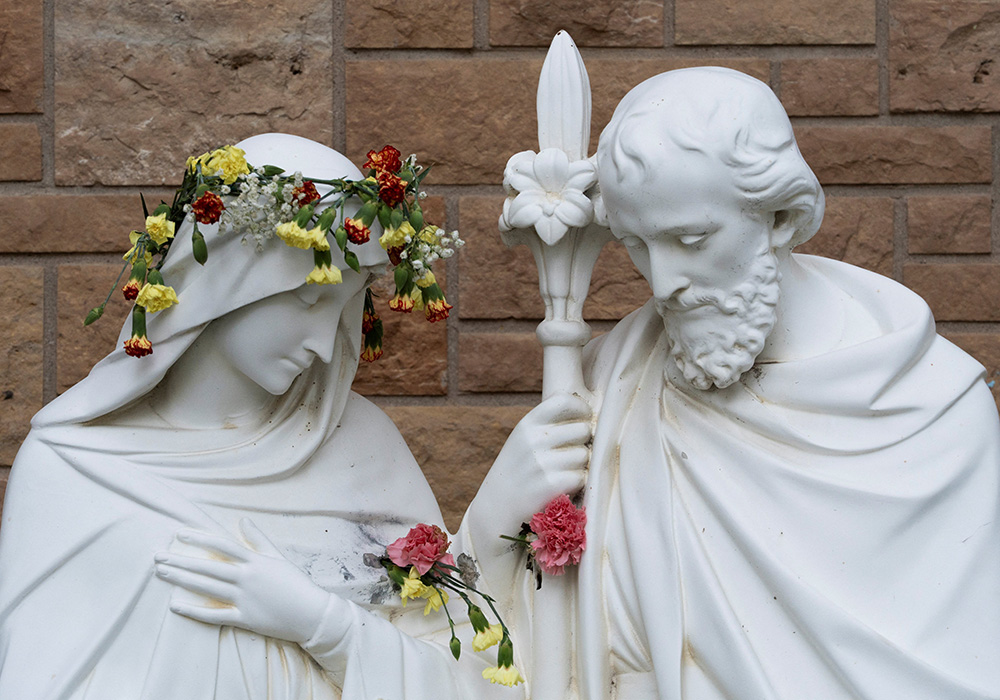 Flowers fill bullet holes on a Holy Family statue outside Annunciation Church in Minneapolis Sept. 2, 2025, which was the scene of a shooting Aug. 27. The shooter opened fire with a rifle through the windows of the church and struck children from the parish school who were attending Mass during the first week of school, killing two and wounding more than 20 others. (OSV News photo/Reuters/Tim Evans)
