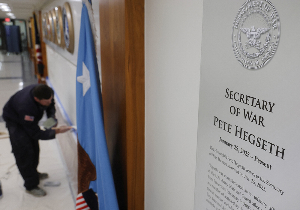 A sign that reads "Pete Hegseth - Secretary of War" hangs as a worker prepares a wall for new signs after U.S. President Donald Trump ordered the Department of Defense to be renamed as the "Department of War," at the Pentagon in Arlington, Virginia, Sept. 5, 2025. (OSV News/Reuters/Jonathan Ernst)