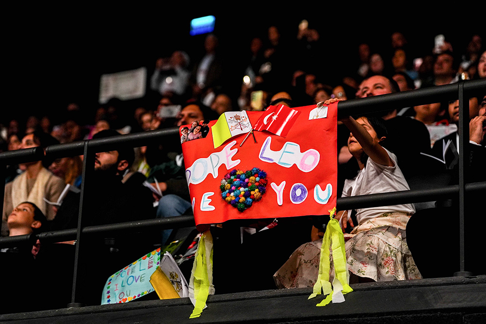 A child holds a handmade sign reading, “Pope Leo, we love you,” as Pope Leo XIV celebrates Mass with Turkey’s Catholic communities at the Volkswagen Arena in Istanbul Nov. 29, 2025. (CNS/Lola Gomez)
