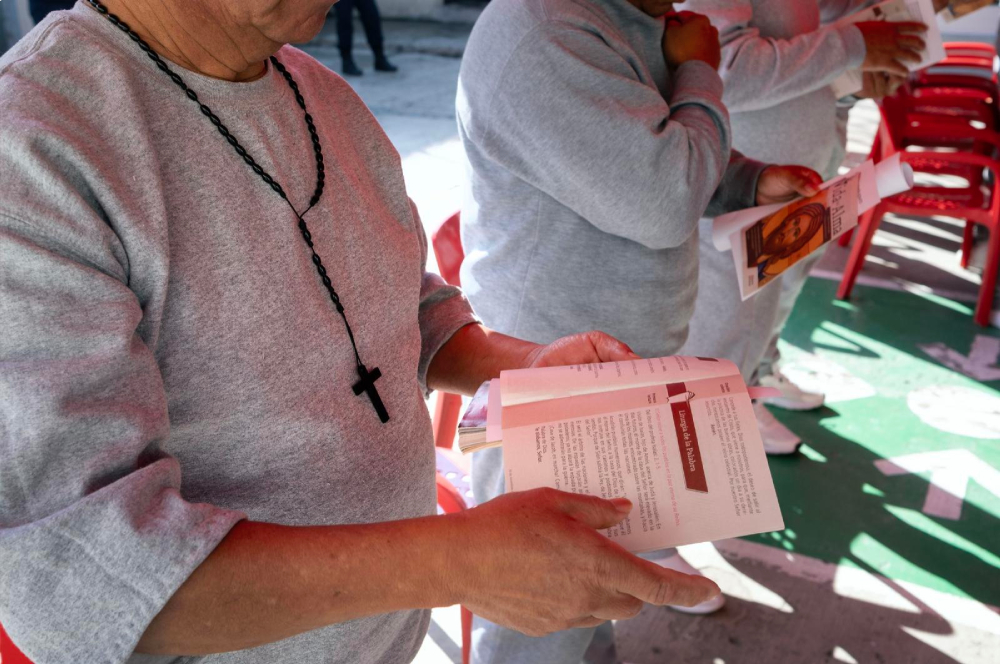 Un recluso de la Penitenciaría Estatal La Mesa lee un programa durante la misa celebrada en la prisión de Tijuana, México, el 1 de diciembre de 2025. La misa se celebró el día del cumpleaños de la madre Antonia Brenner. (Fotro: OSV News/David Maung)