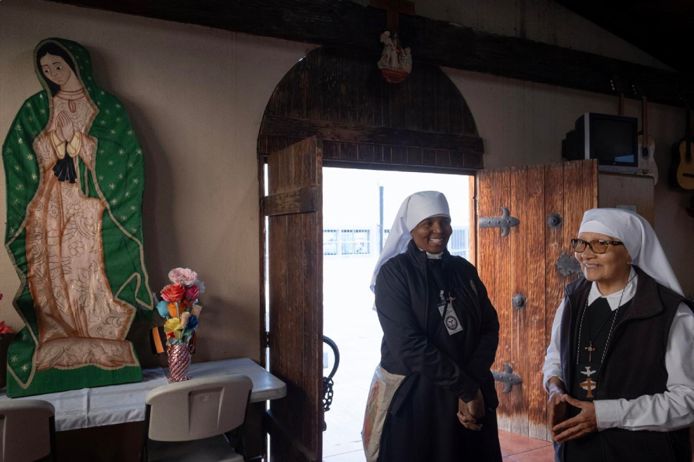 Las hermanas Ann Gertrude Djuidje, de 56 años, de Camerún, y Nelida Molina, de 77, de Perú, sonríen al entrar en la capilla católica de la Penitenciaría Estatal de La Mesa antes de la misa celebrada en la prisión de Tijuana, México, el 1 de diciembre de 2025. (Foto: OSV News/David Maung)