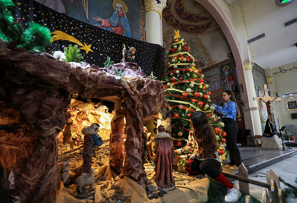 Palestinian girls decorate a Christmas tree and Nativity inside Holy Family Church in Gaza City Dec. 9, 2025, as the community prepared for modest Christmas celebrations after two years of war. (OSV News/Reuters/Dawoud Abu Alkas)