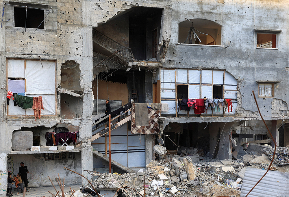 Palestinians stand inside a residential building Dec. 13, 2025, that was damaged during the war in Gaza City. (OSV News/Reuters/Dawoud Abu Alkas)